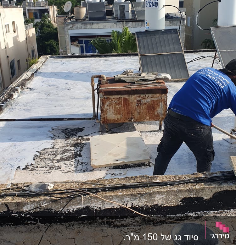 אדם מורח חומר איטום על גג עם מברשת